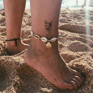 Shell Beads Anklet Worn On Beach With A Cat Tattoo